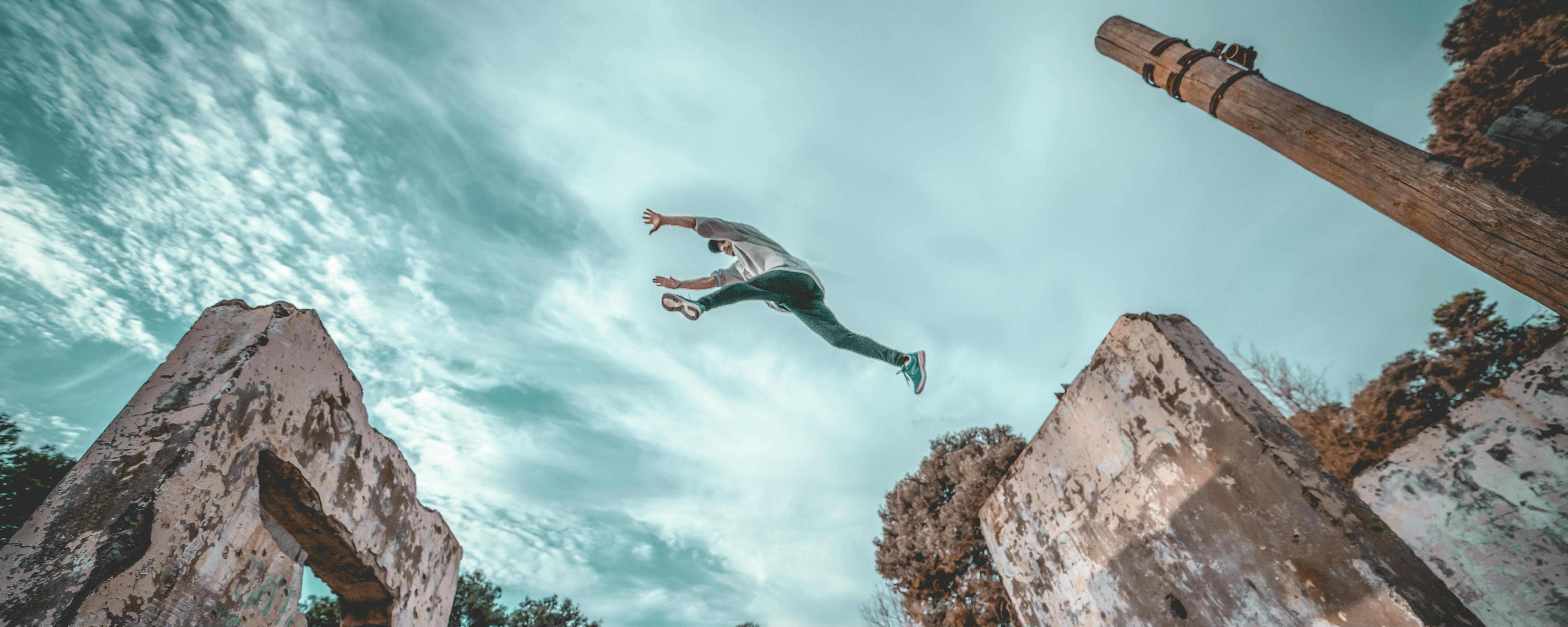 Person jumping between tall stones