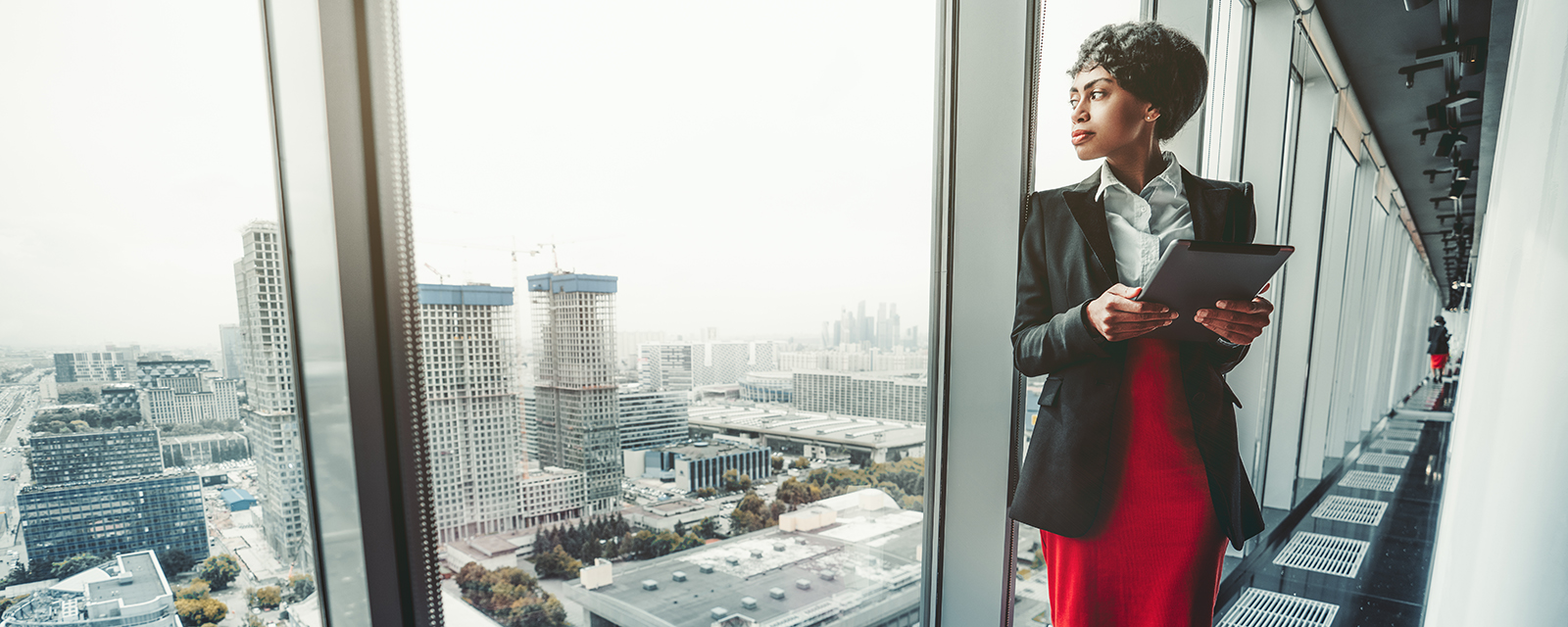 Woman looking out of an office building window