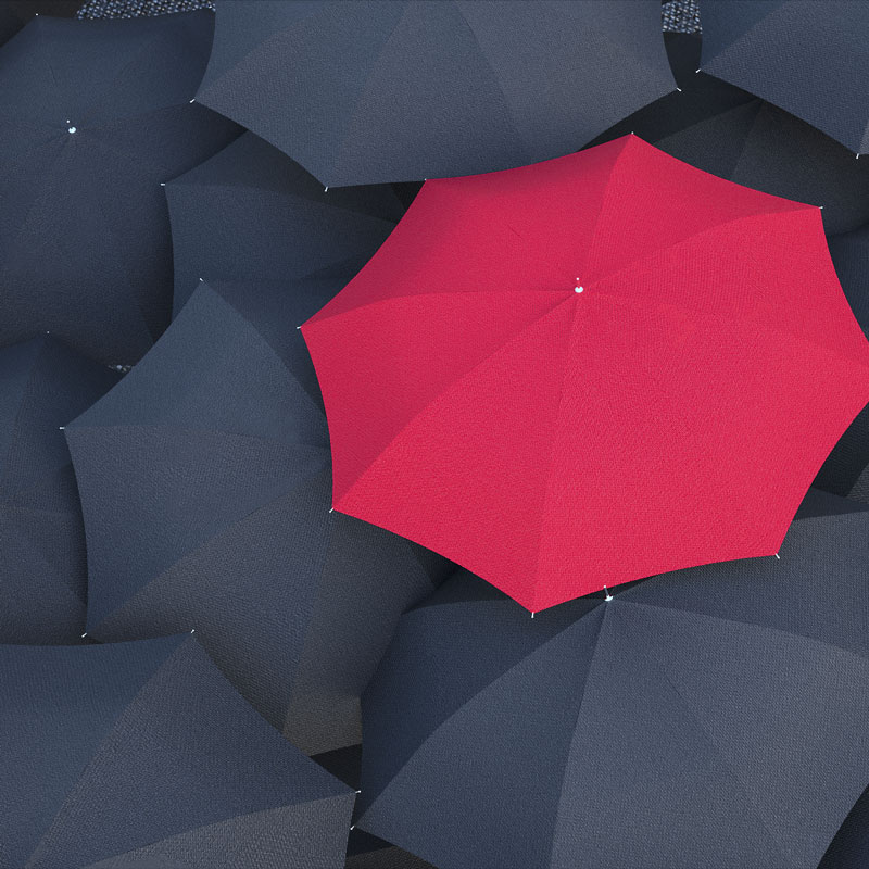 Red umbrella within black umbrellas
