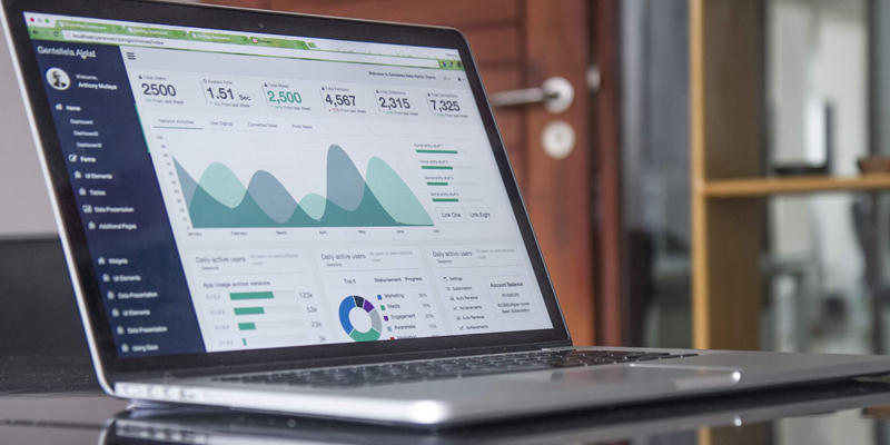 Laptop computer with business graphs and charts on screen