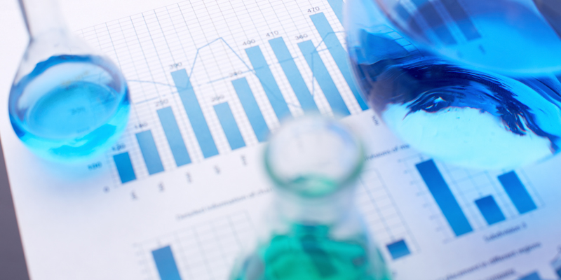 Test-tubes with blue liquids over business document