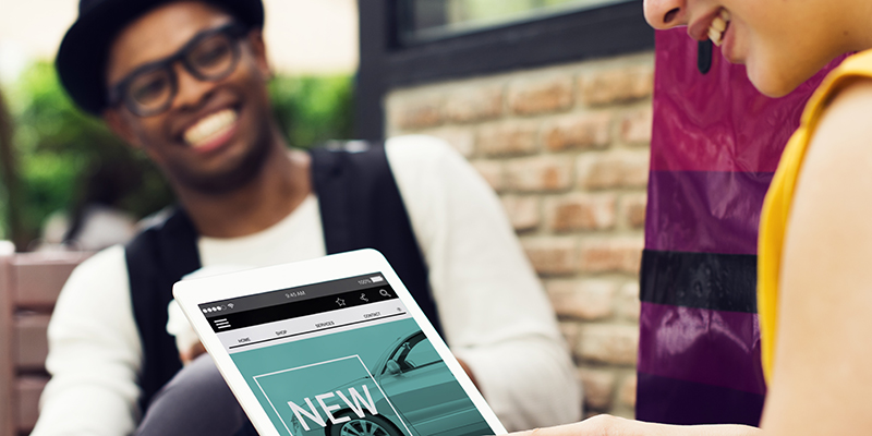 Two people shopping for a car using a tablet