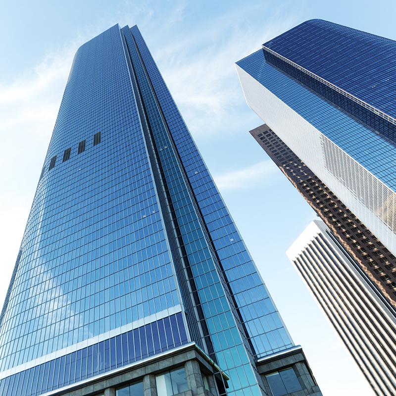 Upward view of modern office building in cloud sky