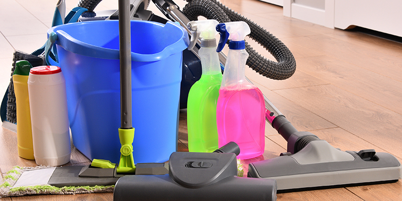 Vacuum cleaner and variety of detergent bottles and chemical cleaning supplies on the floor