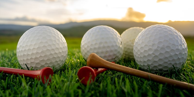 close up the golf ball and tee pegs on the green background