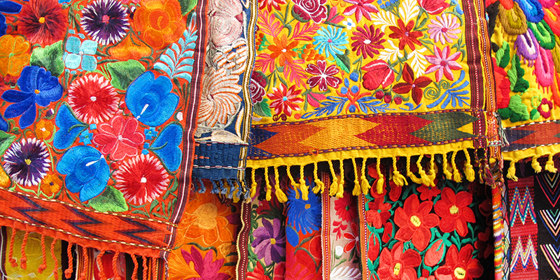 Colorful hand embroidered fabrics and tablecloths in an outdoor market in Mexico City, Mexico