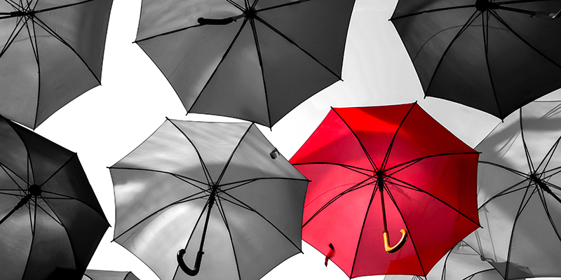 red umbrella standing out from the crowd