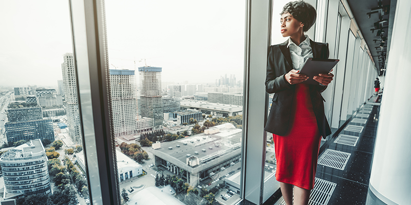 Woman looking out of window of office building