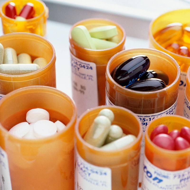 Close-up of an assortment of tablets and capsules in vials