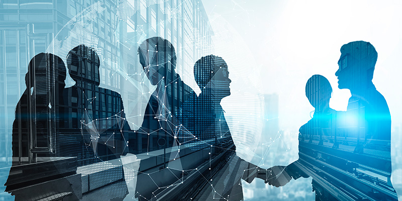 Silhouette of business people shaking hands