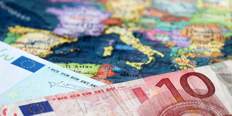Euro banknotes on the map of Europe, selective focus. Concept for european economy, eurozone countries