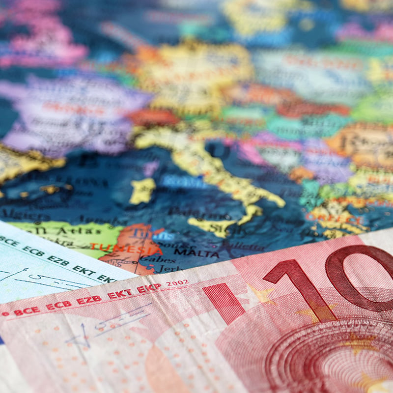 Euro banknotes on the map of Europe, selective focus. Concept for european economy, eurozone countries