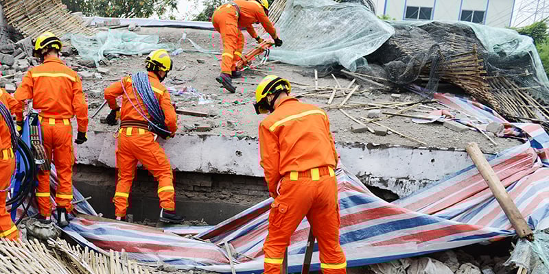 Search and rescue forces search through a destroyed building.
