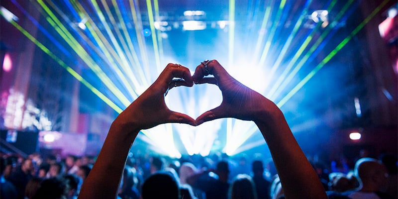 Person making a heart with their hands during a concert