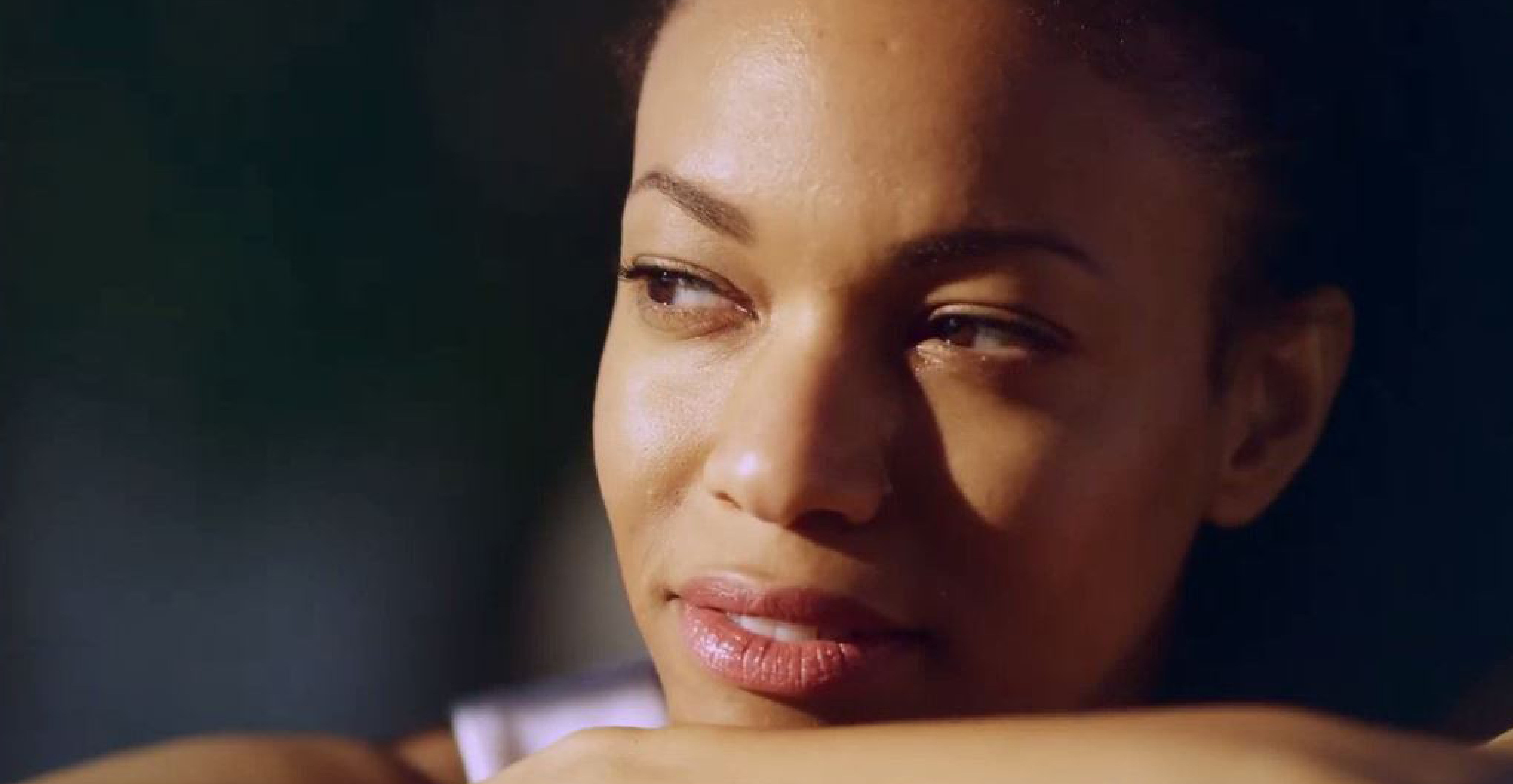 Woman resting her chin on her arm looking off to the side