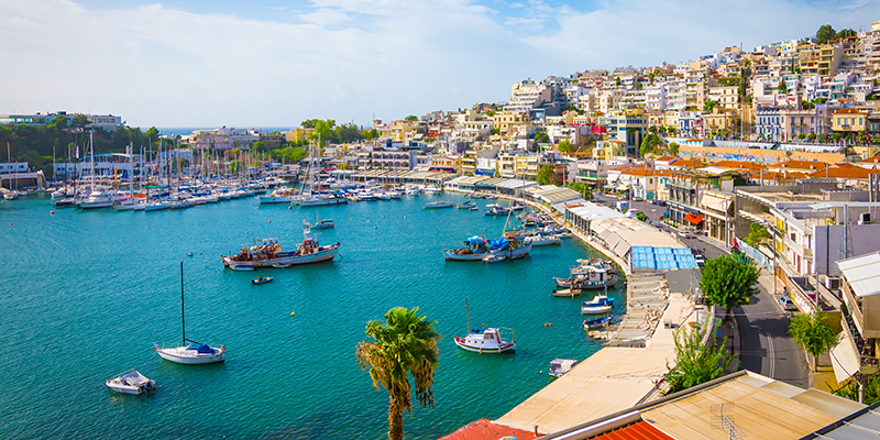 Small marina with boats and yachts at daytime. Landscape with many restaurants close to the harbour of Mikrolimano, Piraeus, Athens, Greece