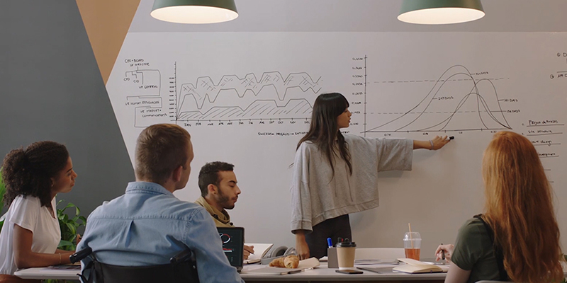 Woman reviewing graph in front of group of people