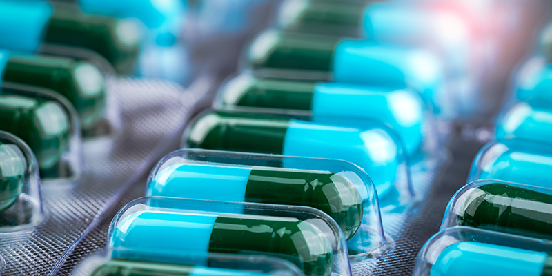 Closeup green-blue antibiotic capsule pills in blister pack