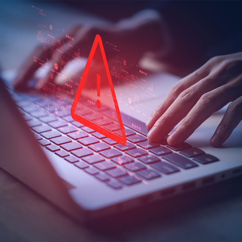 Danger symbol floating over laptop keyboard