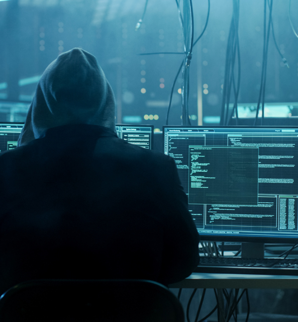 Person in hood hacking computers