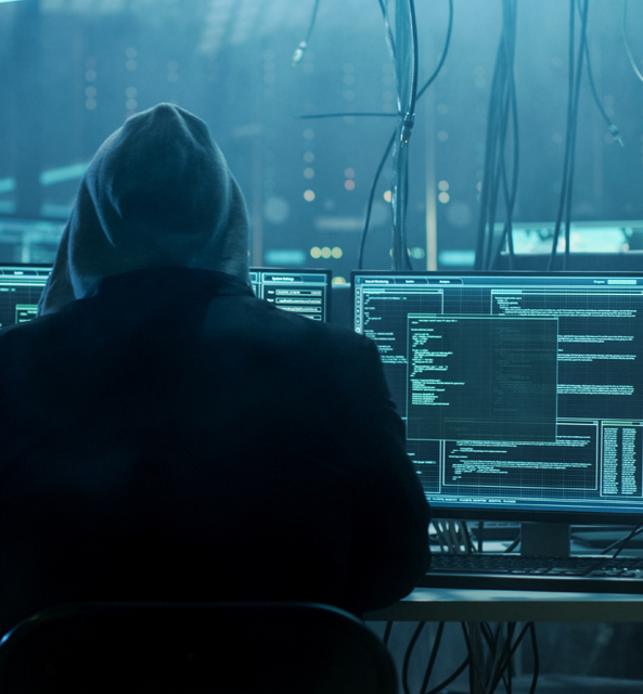 Person in hood hacking computers