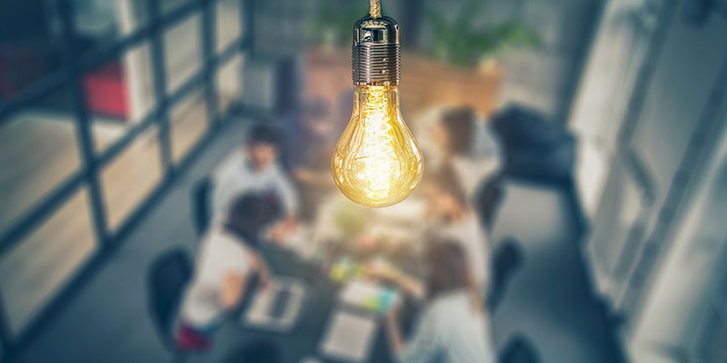 Light bulb over people in a meeting