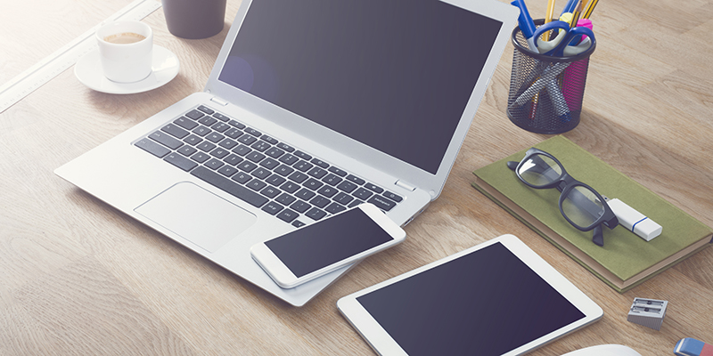 Responsive design mockup for online web design. On table top with different office items