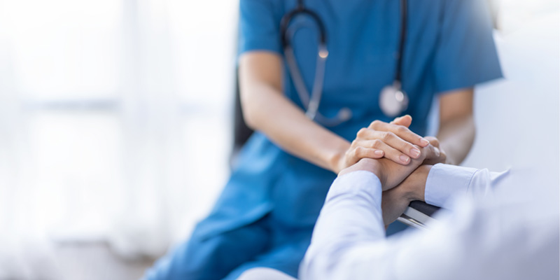 Nurse holding patient's hand