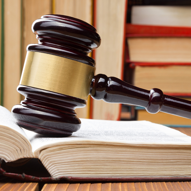 Law book with wooden judges gavel on table