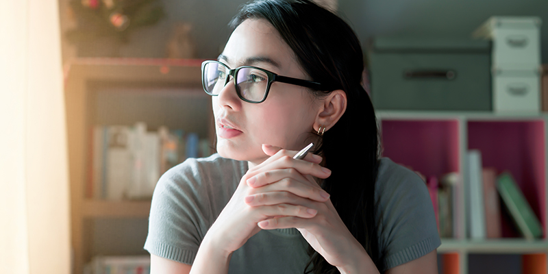 Woman in home office looking through window