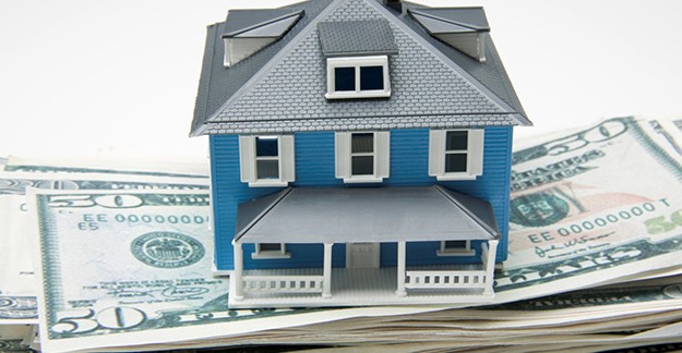 House sitting on a stack of money