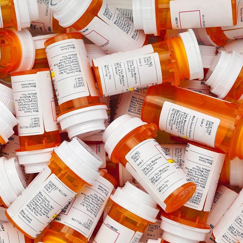 Dozens of prescription medicine bottles in a jumble.