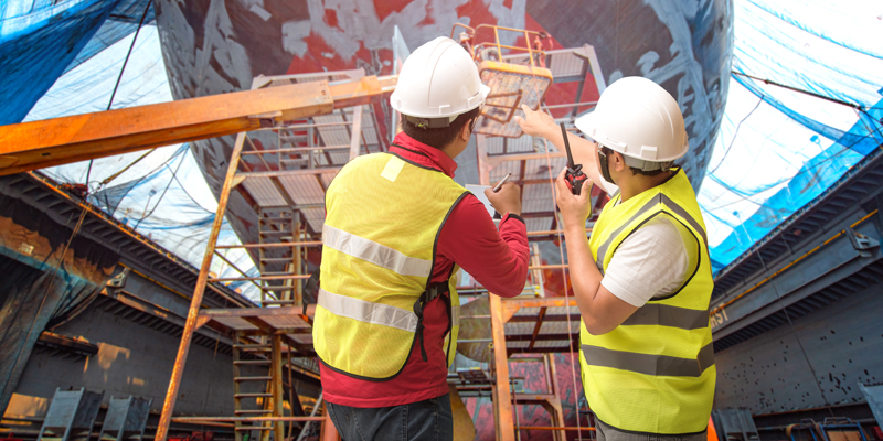 Surveyor inspect the bulk head of commercial cargo ship in floating dry dock, recondition of overhaul repairing and painting, sand blasting in dry dock yard