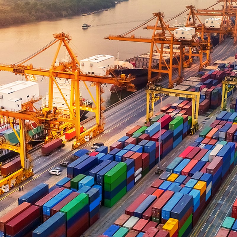 Logistics and transportation of Container Cargo ship and Cargo plane with working crane bridge in shipyard at sunrise
