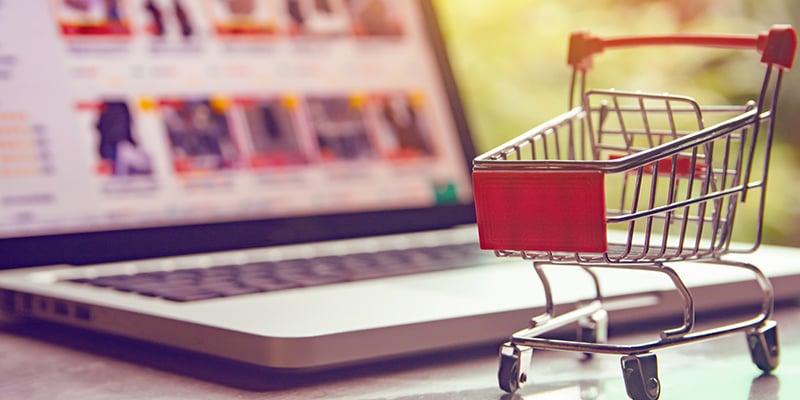 Shopping online concept - shopping cart or trolley on a laptop keyboard. 