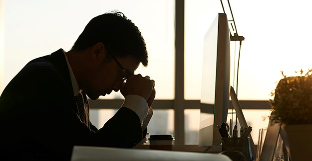Man sitting at desk waiting for download